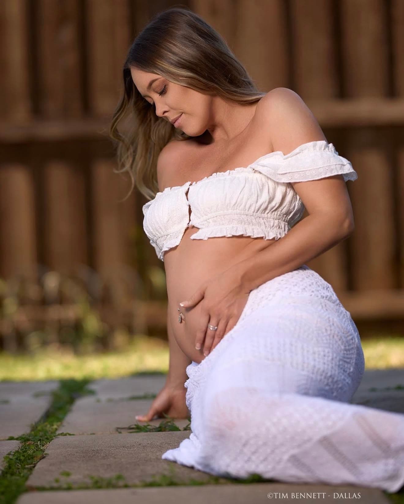 A maternity portrait created at Creative Connect Rowlett with the model wearing white.